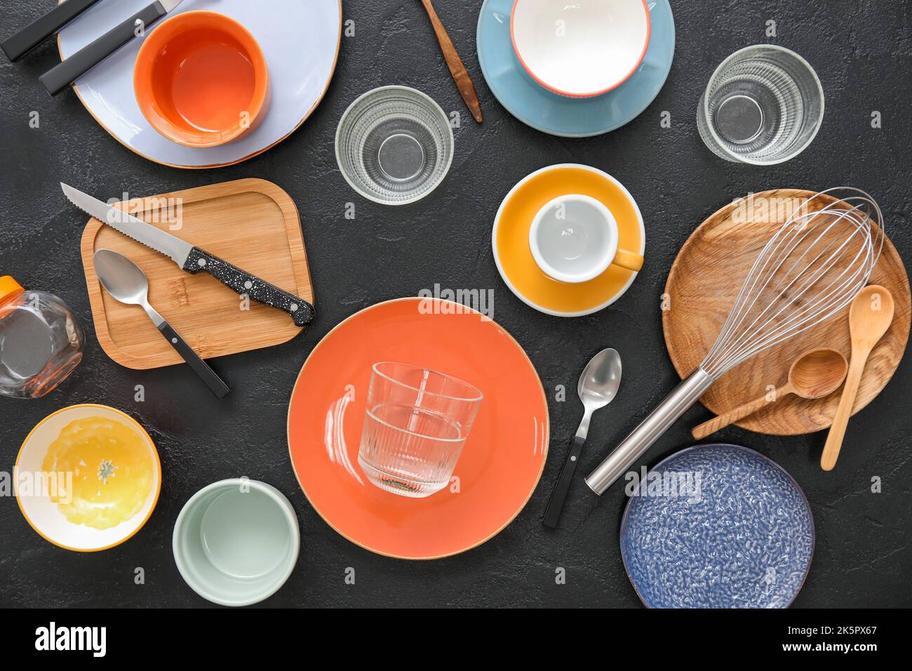 Many different tableware and kitchenware on dark background, top view Stock Photo