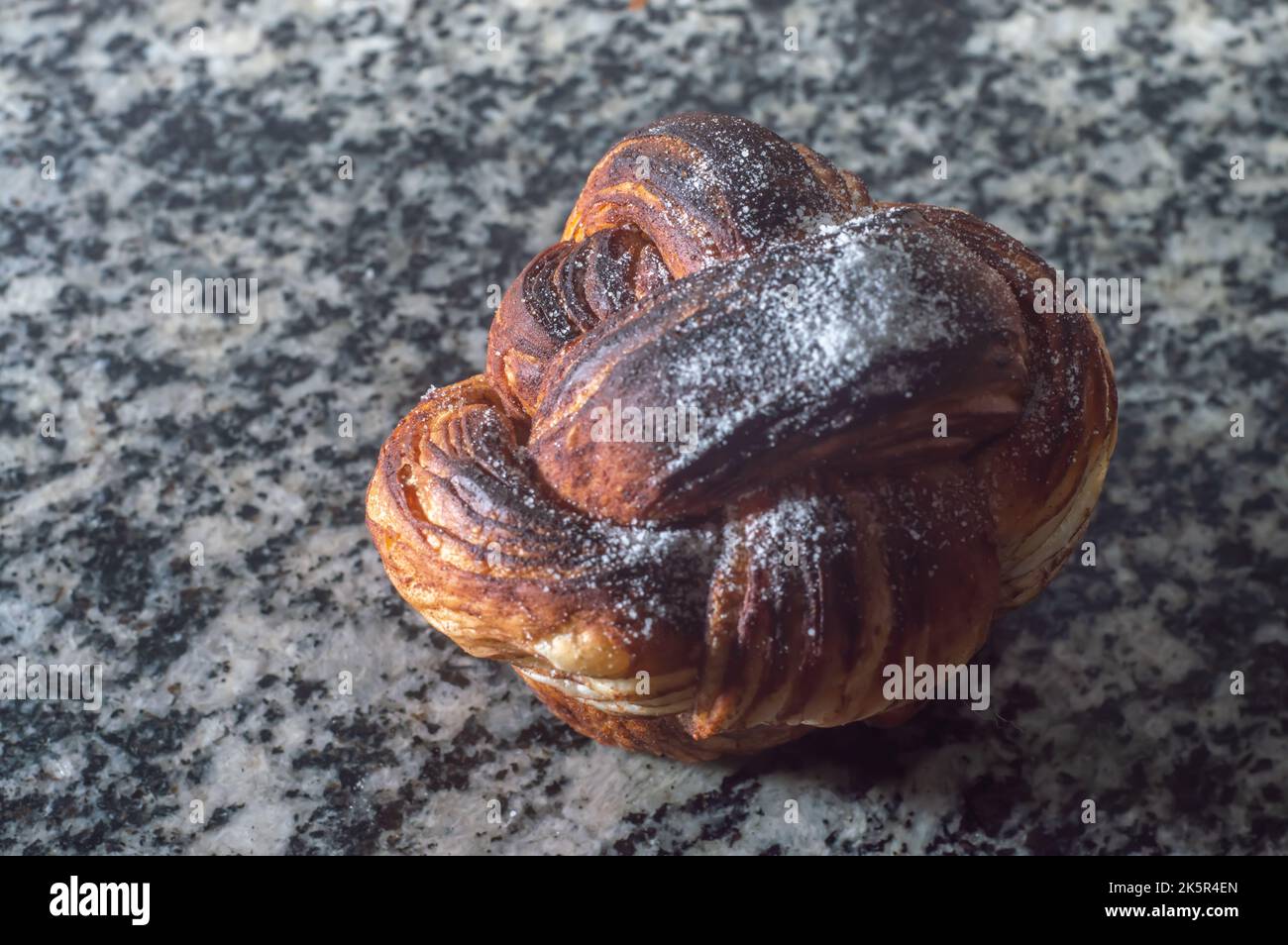 Pastry with sugar dusting on a rustic wood table. Close up with directional lighting for texture detail and copy space for text.. Stock Photo