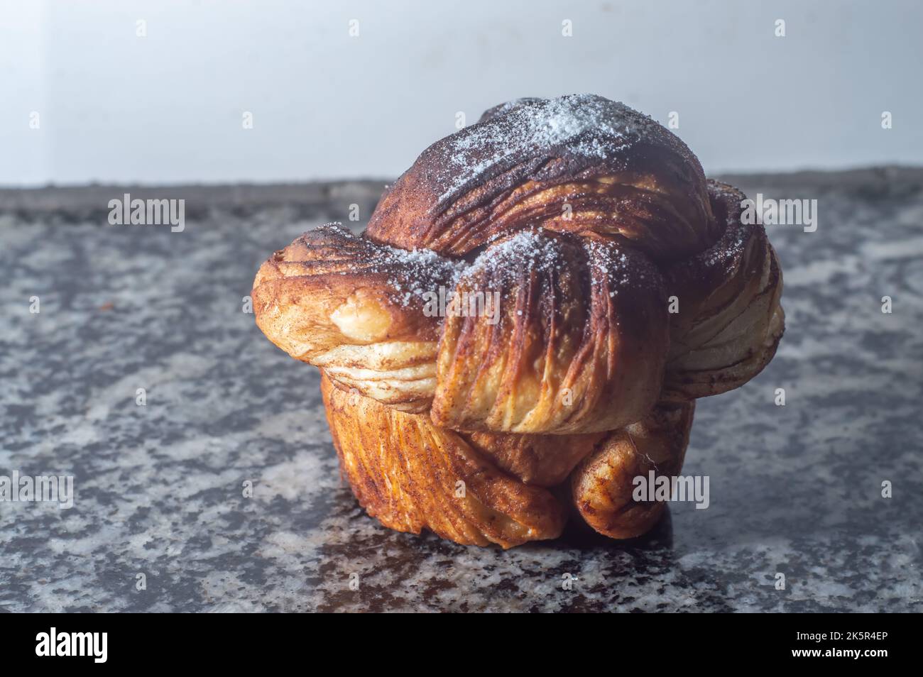 Pastry with sugar dusting on a rustic wood table. Close up with directional lighting for texture detail and copy space for text.. Stock Photo
