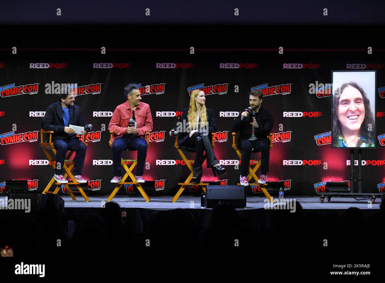 Josh Horowitz, Eric Appel, Evan Rachel Wood and Daniel Radcliffe speak onstage at Let's Get WEIRD panel during New York Comic Con 2022 on October 09, Stock Photo