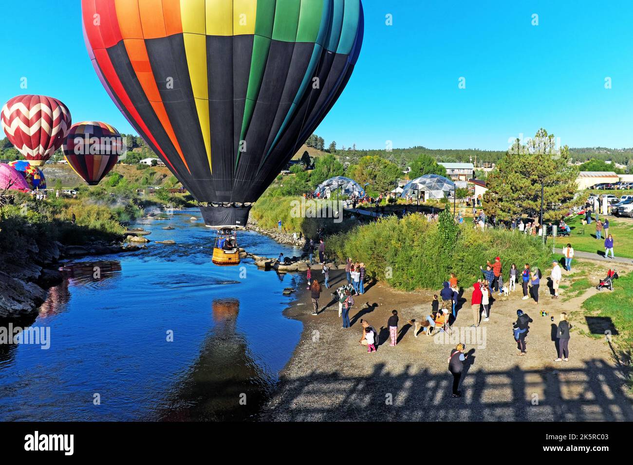 The annual Colorfest Balloon Rally on September 17, 2022, in Pagosa Springs fills the skies with hot air balloons reflected in the San Juan River. Stock Photo