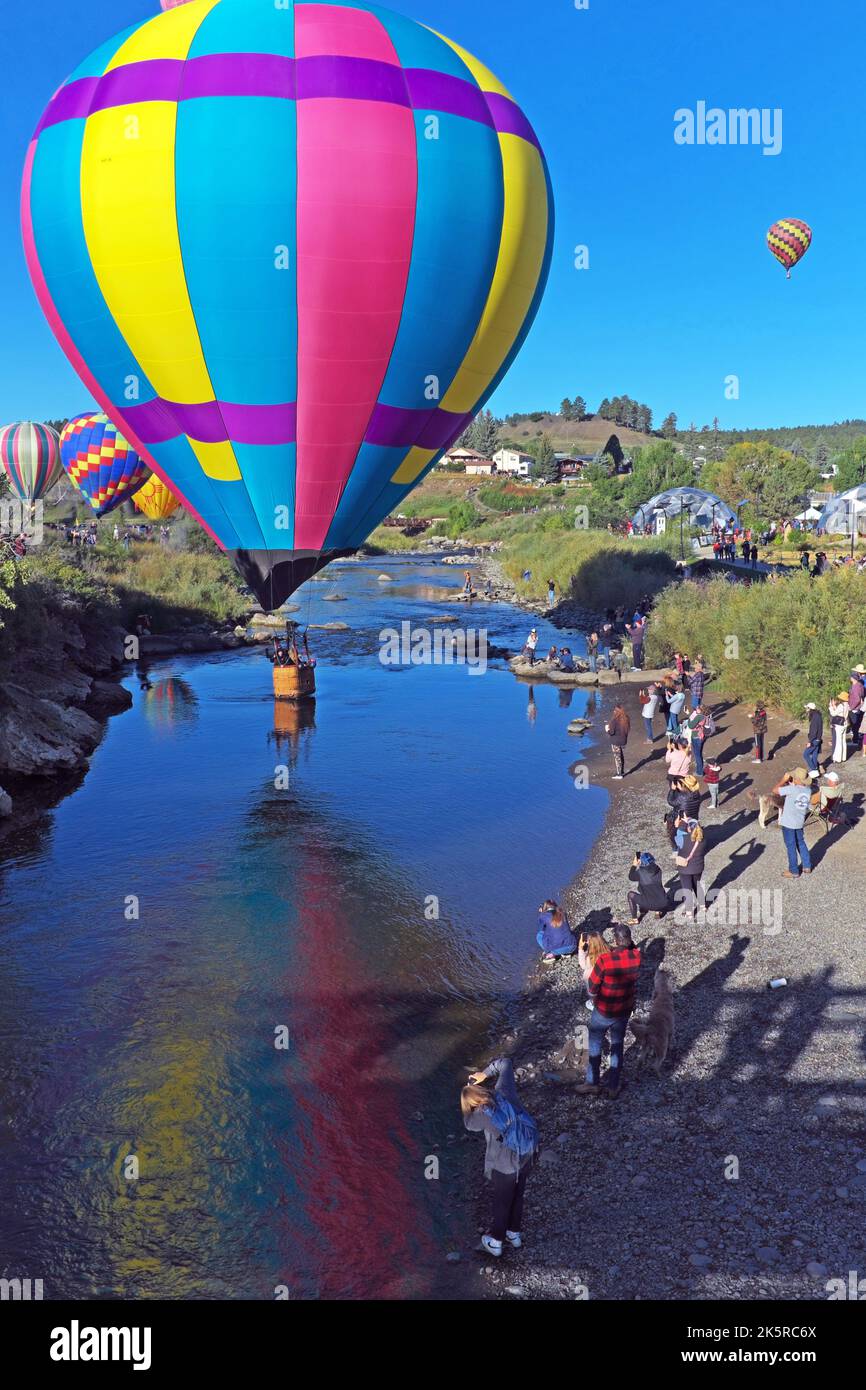 A hot air balloon hovers over the San Juan River in downtown Pagosa Springs, Colorado during the annual Colorfest Balloon Rally on September 17, 2022. Stock Photo