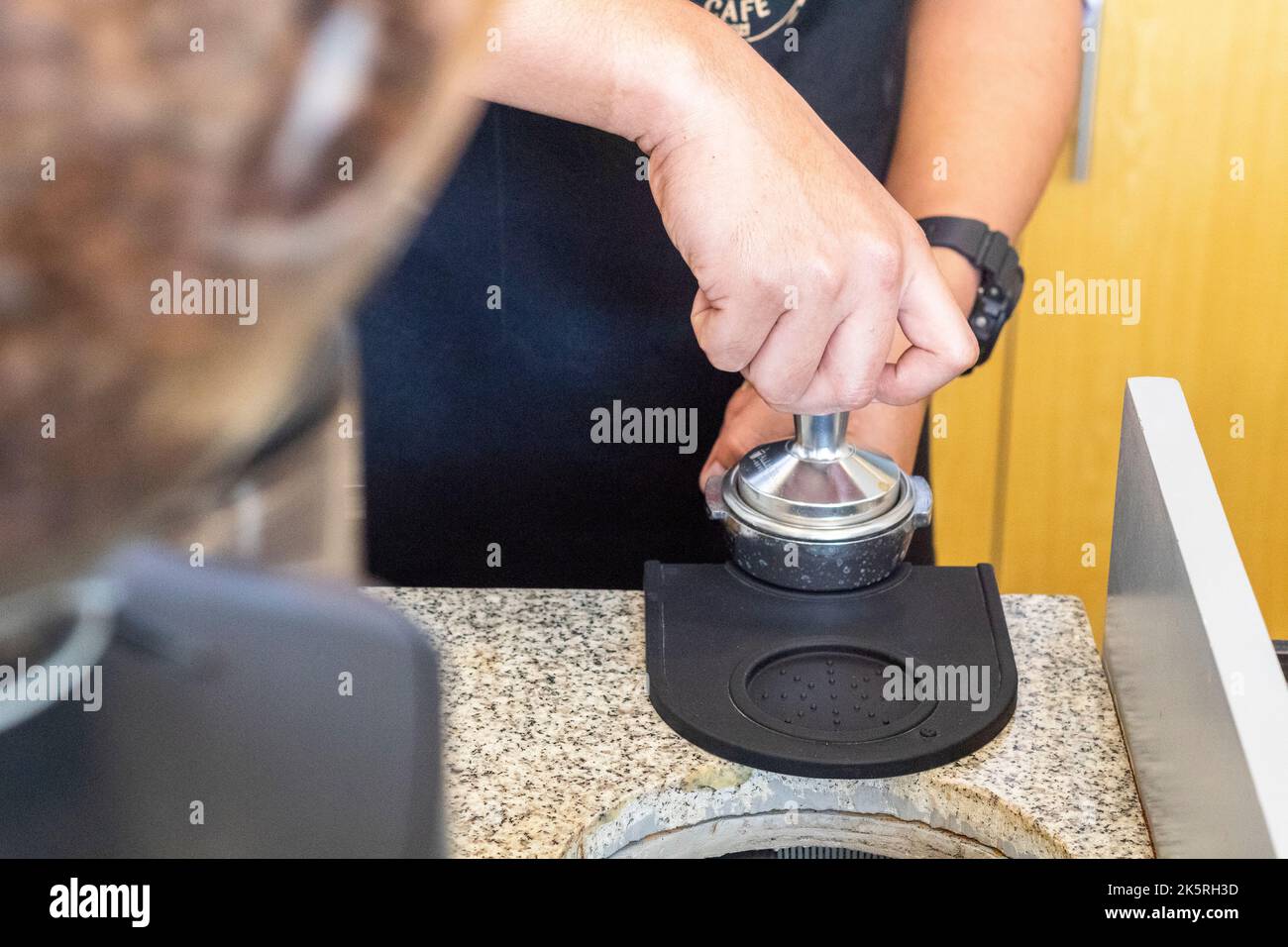 Tamping freshly ground coffee for an espresso at a local cafe in Cebu