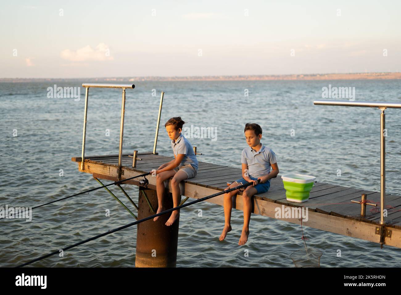 Teenage boys fishing in river at sunset, Washington, USA Stock