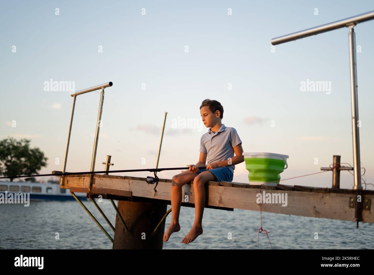 Child fishing on the lake. Kid fisher boy with spinner at river. boy