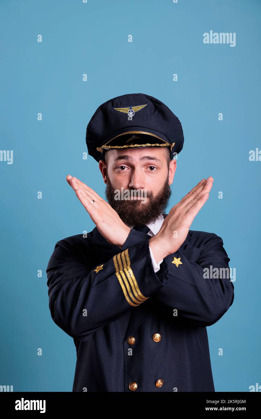 Airplane capitan showing time out gesture with hands, looking at camera doing stop signal. Aviation academy plane pilot front view, airforce aviator with timeout sign, take break, interruption Stock Photo