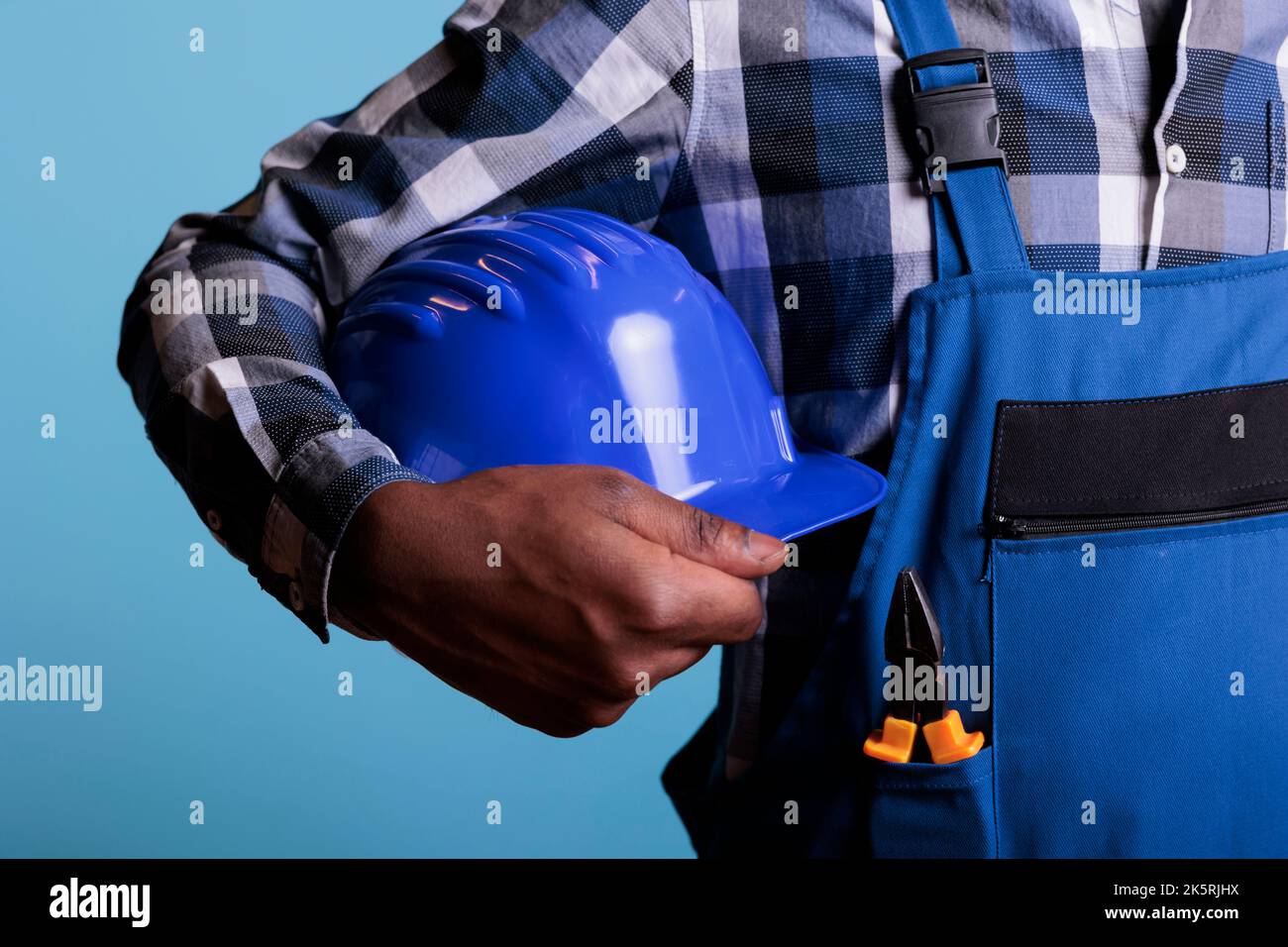 Construction worker holding hard hat hi-res stock photography and ...