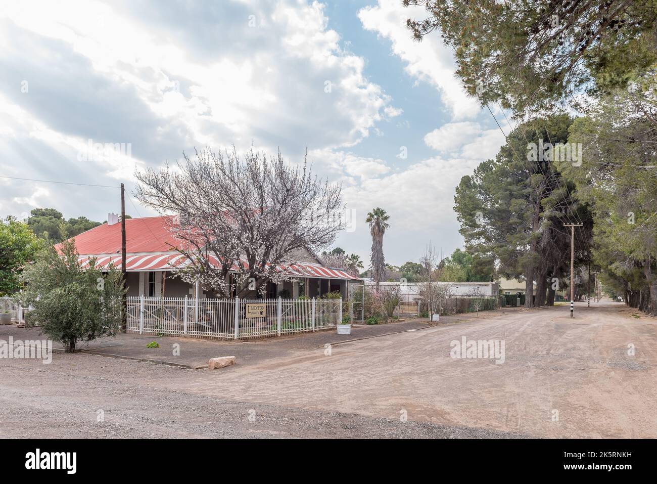 LOXTON, SOUTH AFRICA - SEP 2, 2022: A gravel street scene, with the Loxton Gallery, in Loxton in the Northern Cape Karoo. A flowering pear tree is vis Stock Photo