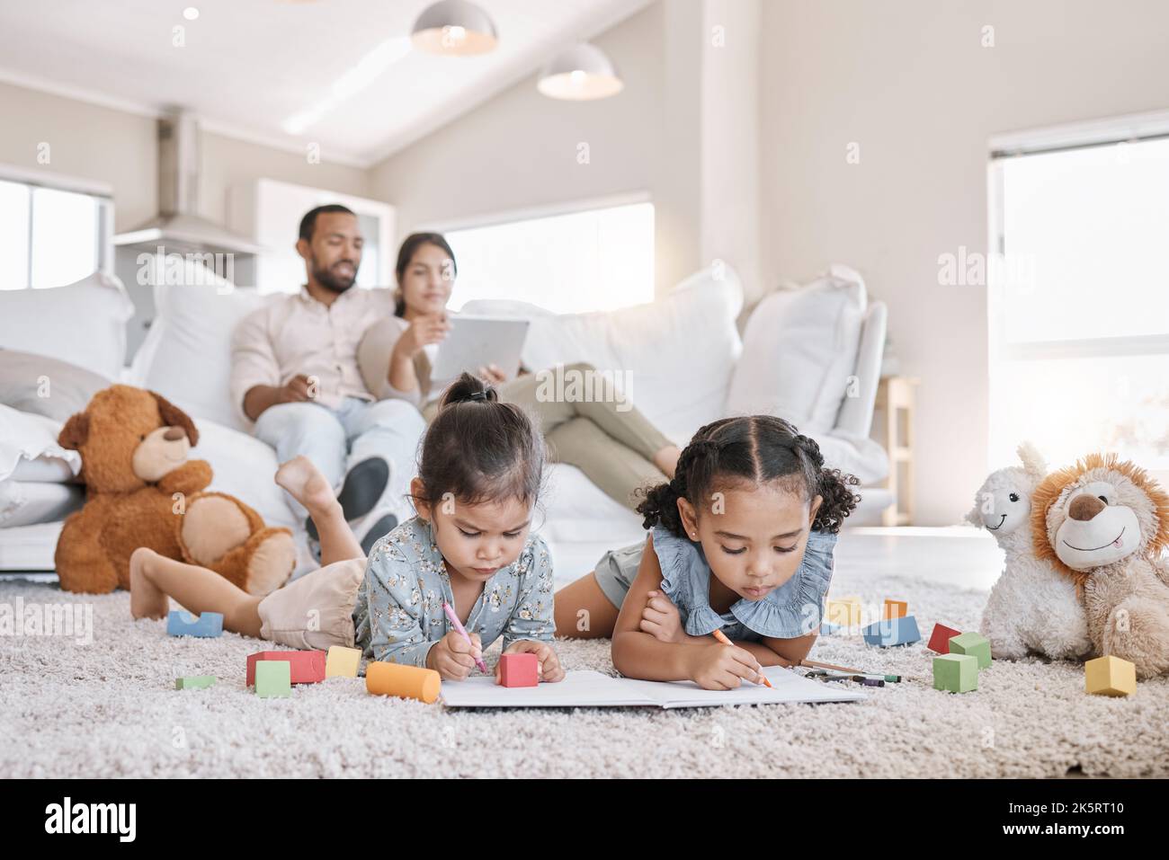 Little two girls drawing with colouring pencils lying on living room ...