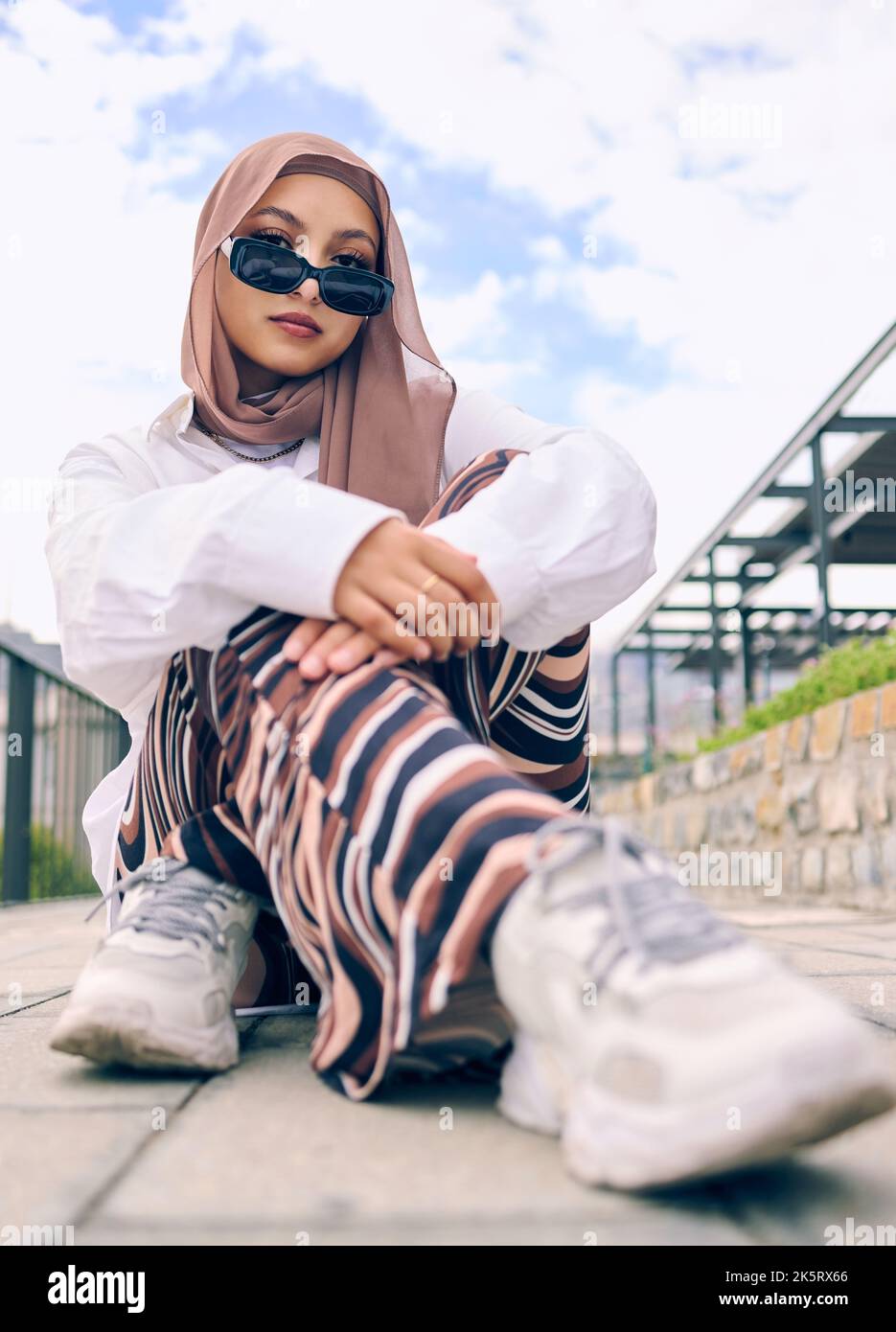 Beautiful young arab woman posing outdoors in a headscarf. Attractive female muslim wearing a hijab posing outside. Shes all about style and fashion Stock Photo