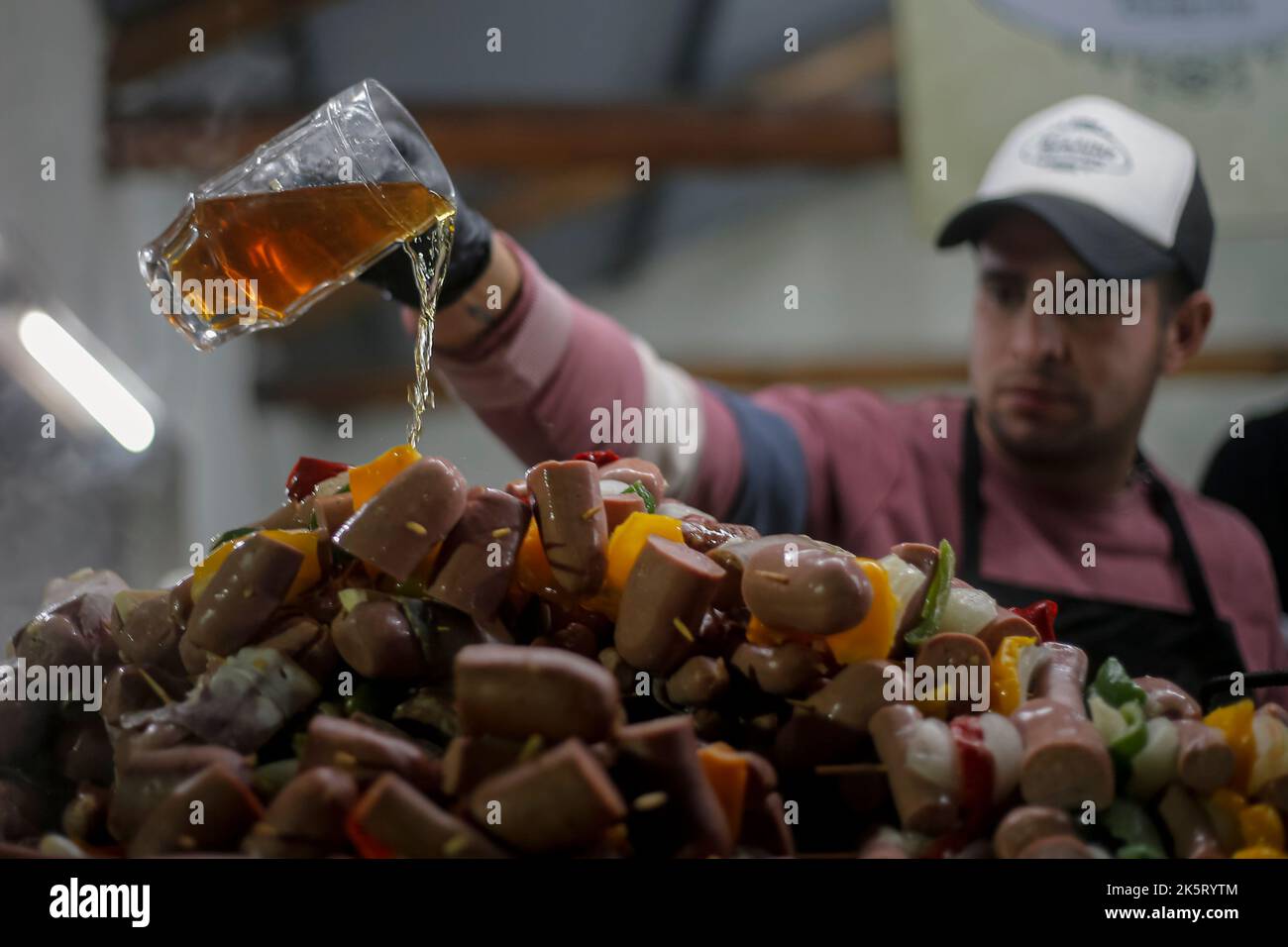 Villa General Belgrano, Argentina. 09th Oct, 2022. A cook pours beer over sausages during the 59th edition of Oktoberfest in Argentina. Credit: Diego Lima/dpa/Diego Lima/dpa/Alamy Live News Stock Photo