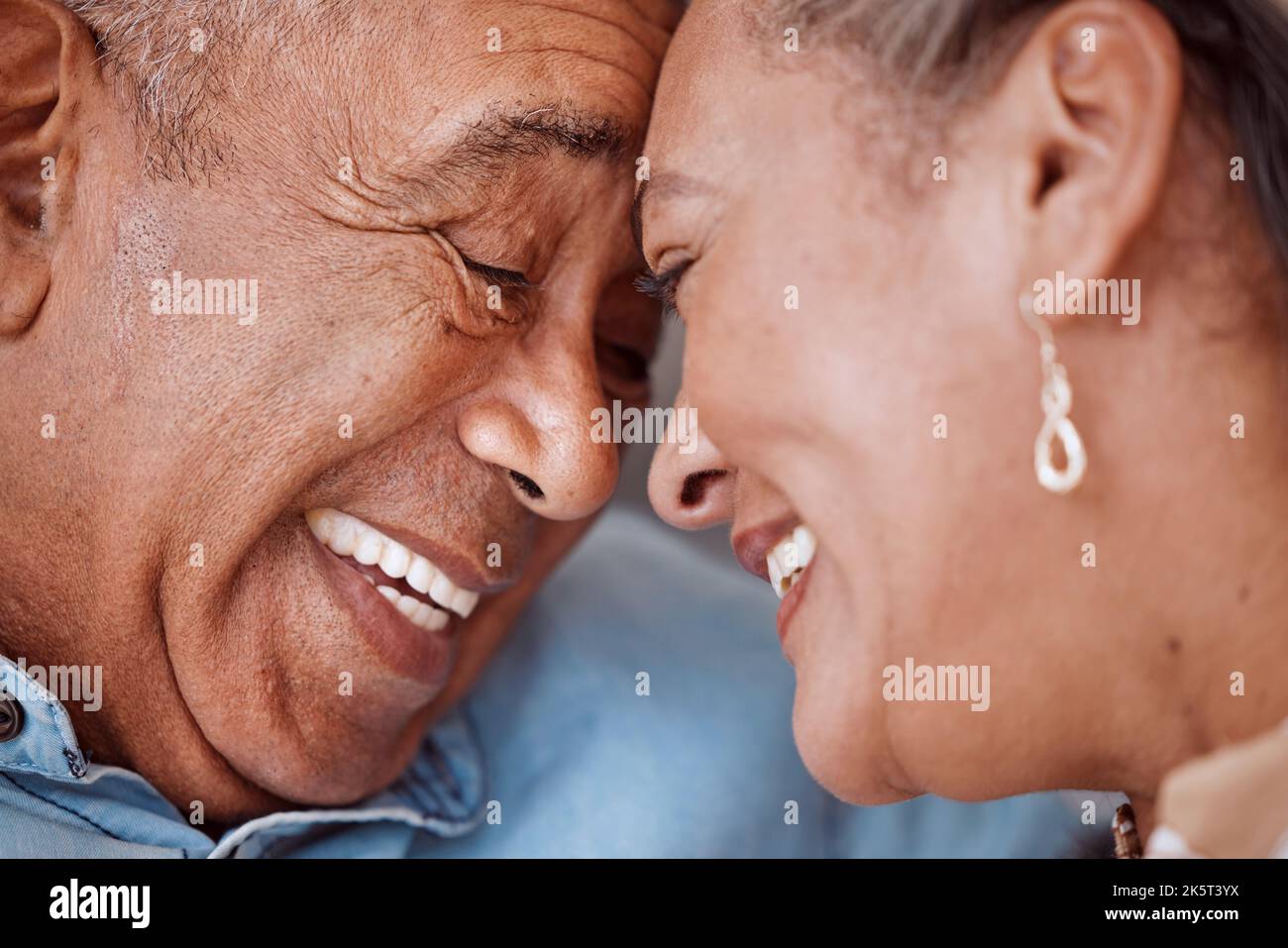 Love, couple and face of senior man and woman embracing and laughing, relax and bonding in their living room. Rest, happiness and retirement by caring Stock Photo