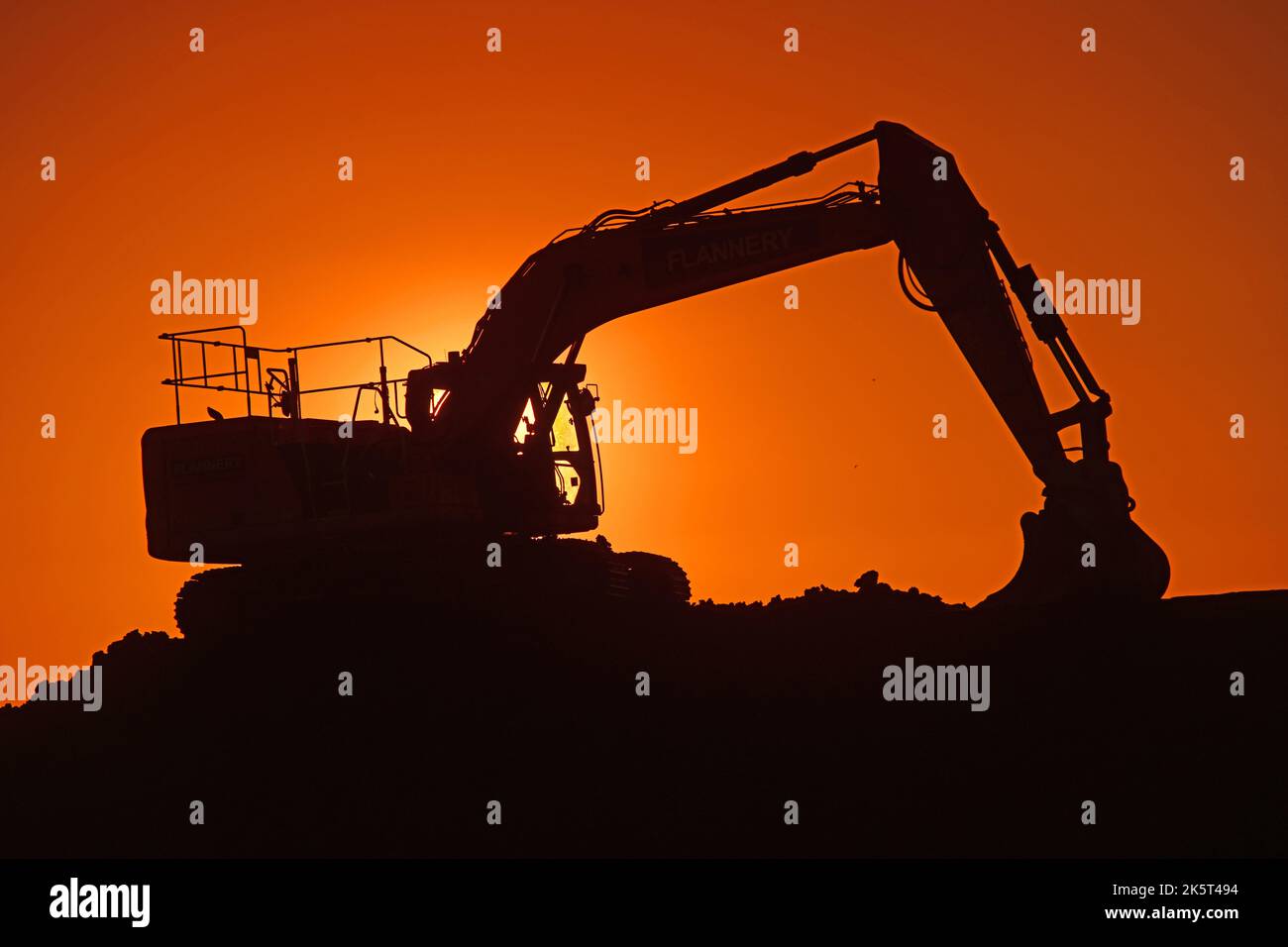caterpillar digger working on site at sunset united kingdom Stock Photo