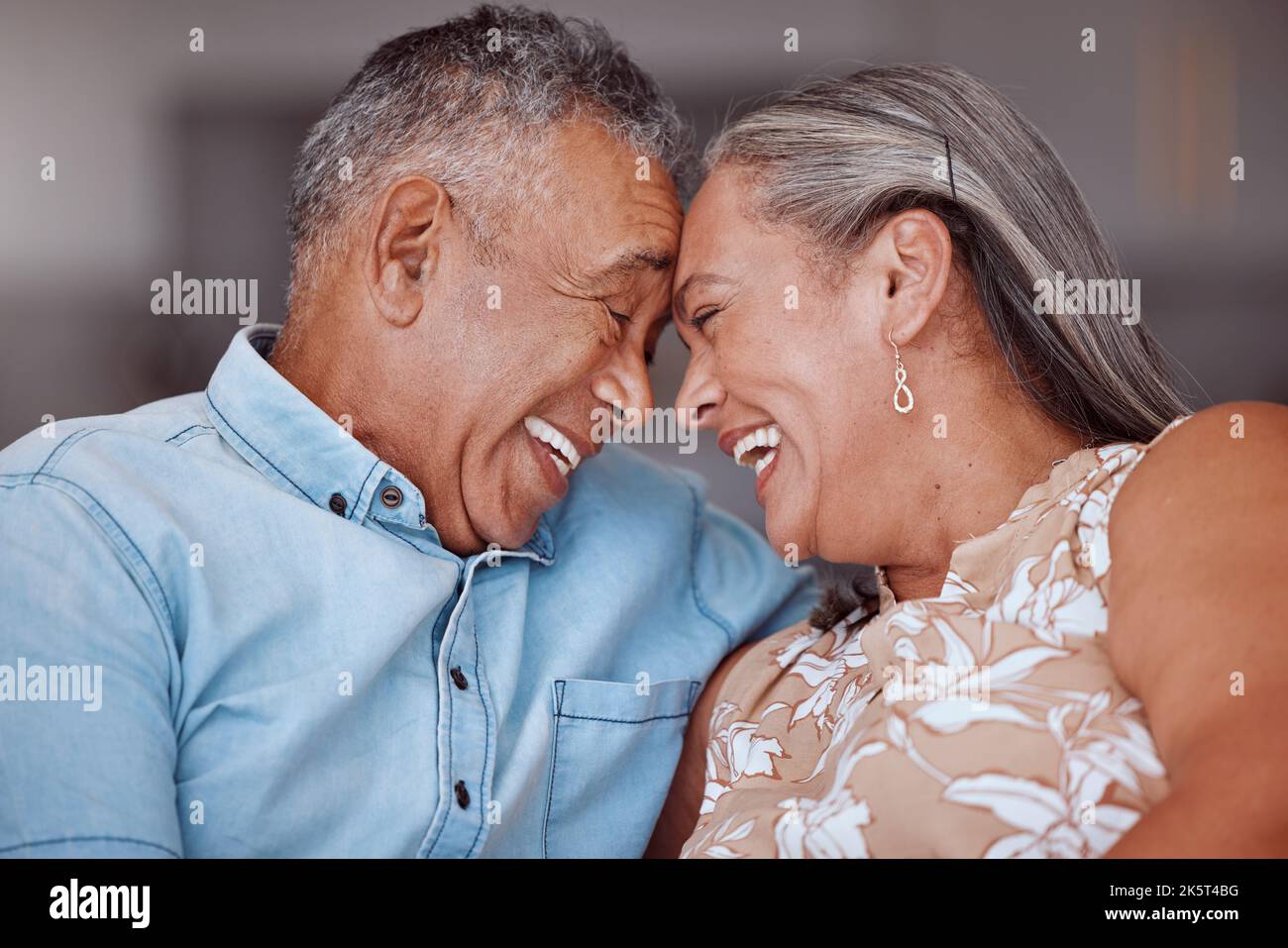 Love, laugh and happy elderly couple relax and bond in a living room
