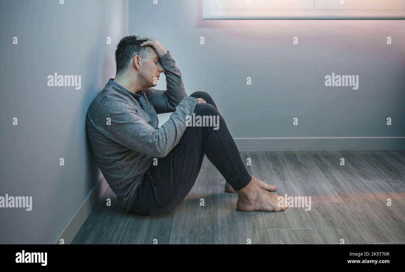 Man with problems resting sitting on the floor Stock Photo