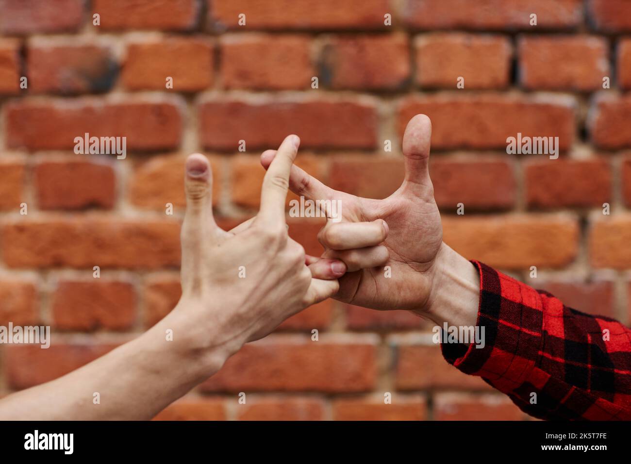 Close up of two unrecognizable young men greeting each other with