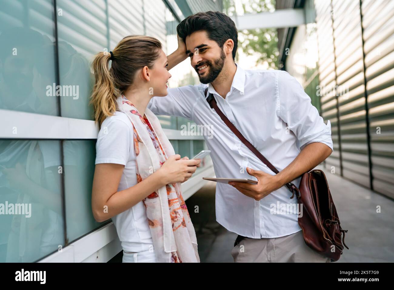 Two young successful business colleagues talking, working together outdoors. Stock Photo