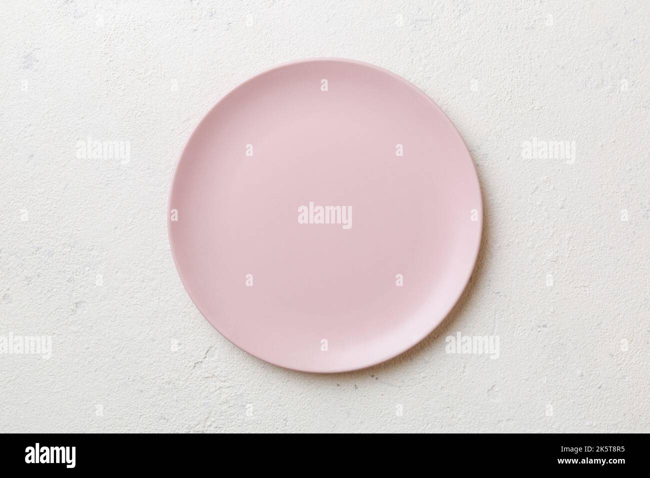 Top view of empty pink plate on cement background. Empty space for your ...