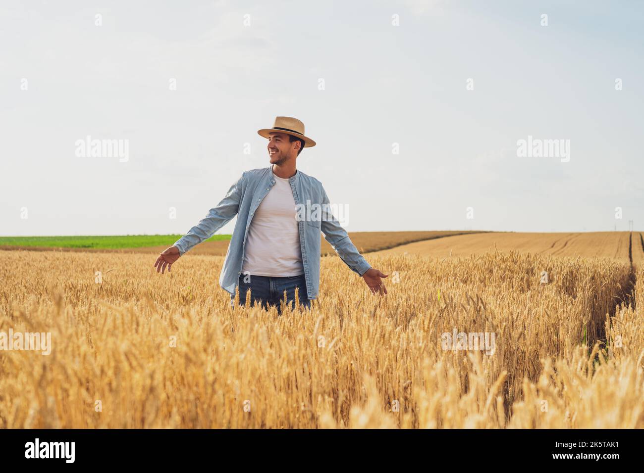 Happy farmer is standing in his growing wheat field Stock Photo - Alamy