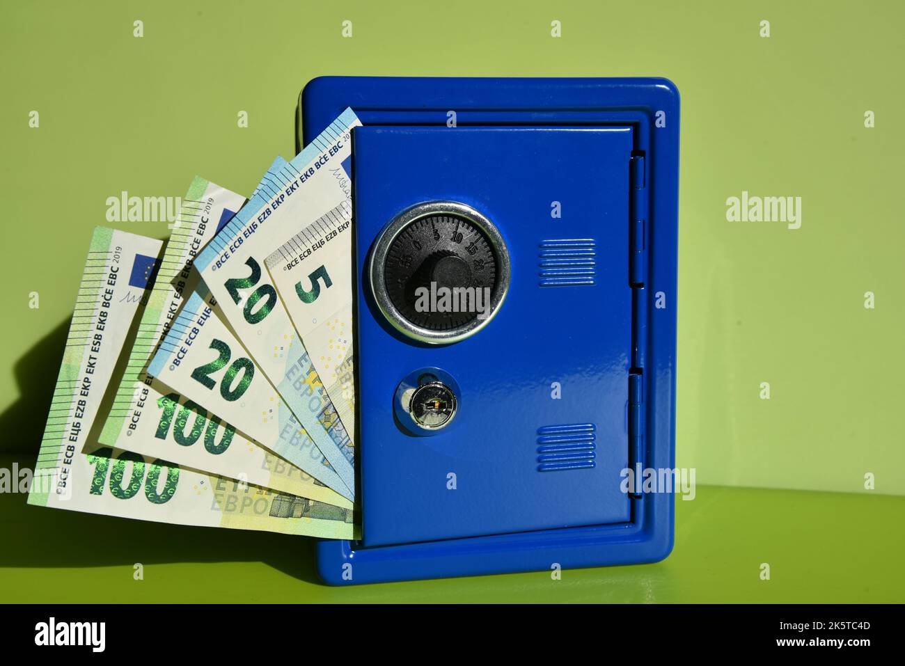a small blue toy safe with euro bills Stock Photo