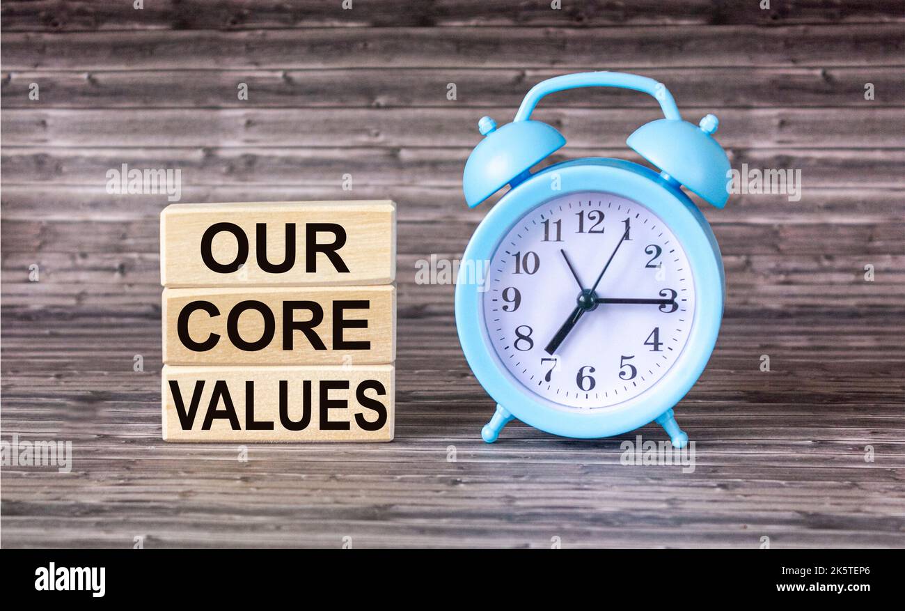 Conceptual words Our Core Values on wooden blocks on wooden background with clock. Business value and our concept of core values. Copy space. Stock Photo