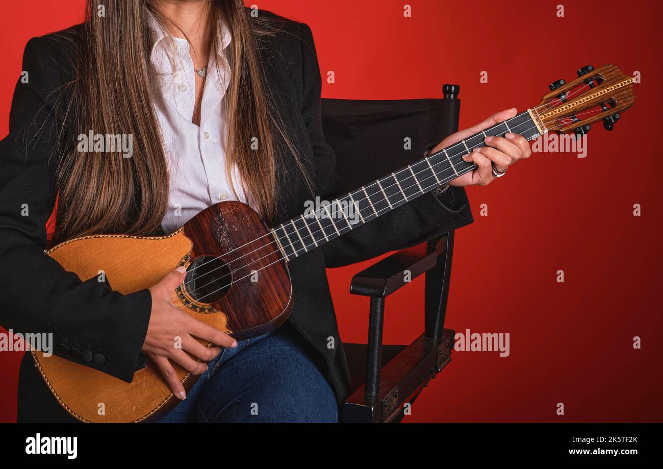 Young woman playing a CUATRO, typical Venezuelan instrument. Recording session, Concept of music and typical instruments. Stock Photo