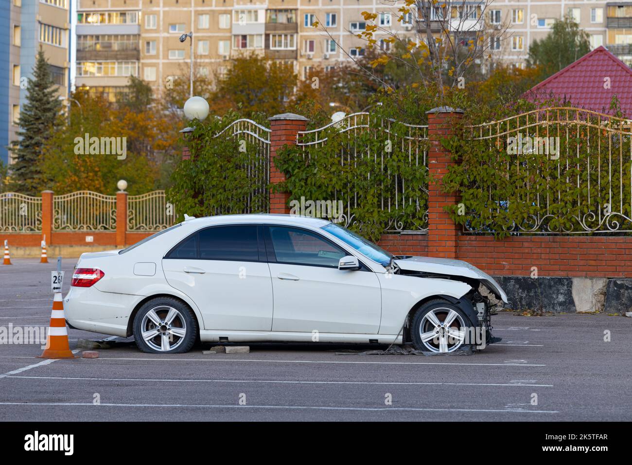 badly damaged passenger car stands in an empty parking lot. wrecked car