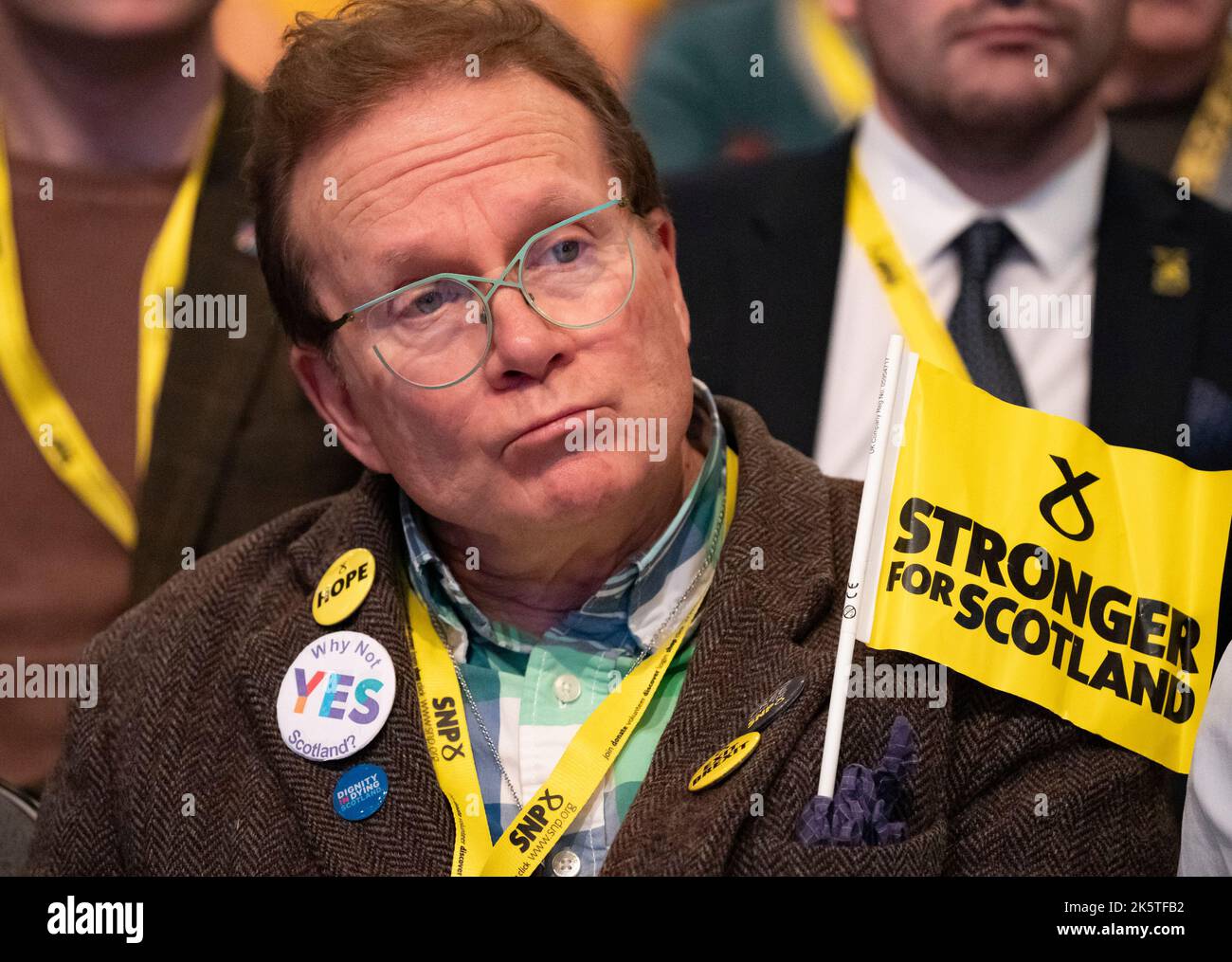 Aberdeen, Scotland, UK. 10th October 2022. Delegate with pro Independence badges and flag at  the Scottish National Party Conference on day three in Aberdeen, Scotland. Because of the Covid pandemic this year is the first time Scottish National Party Members have met for a conference since October 2019. Iain Masterton/Alamy Live News Stock Photo