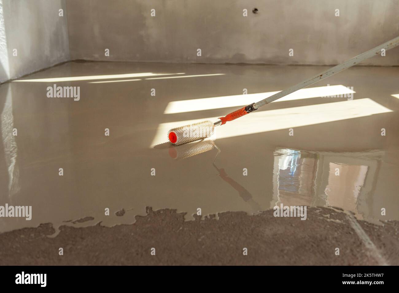 Needle roller for selfleveling floors. Leveling the floors with a cement mixture Stock Photo