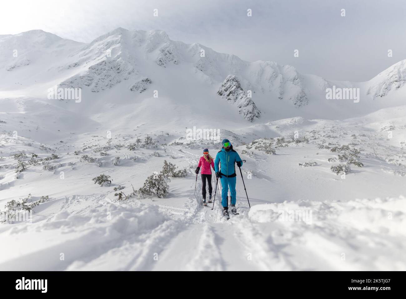 Ski touring couple hiking up a mountain in the Low Tatras in Slovakia. Stock Photo