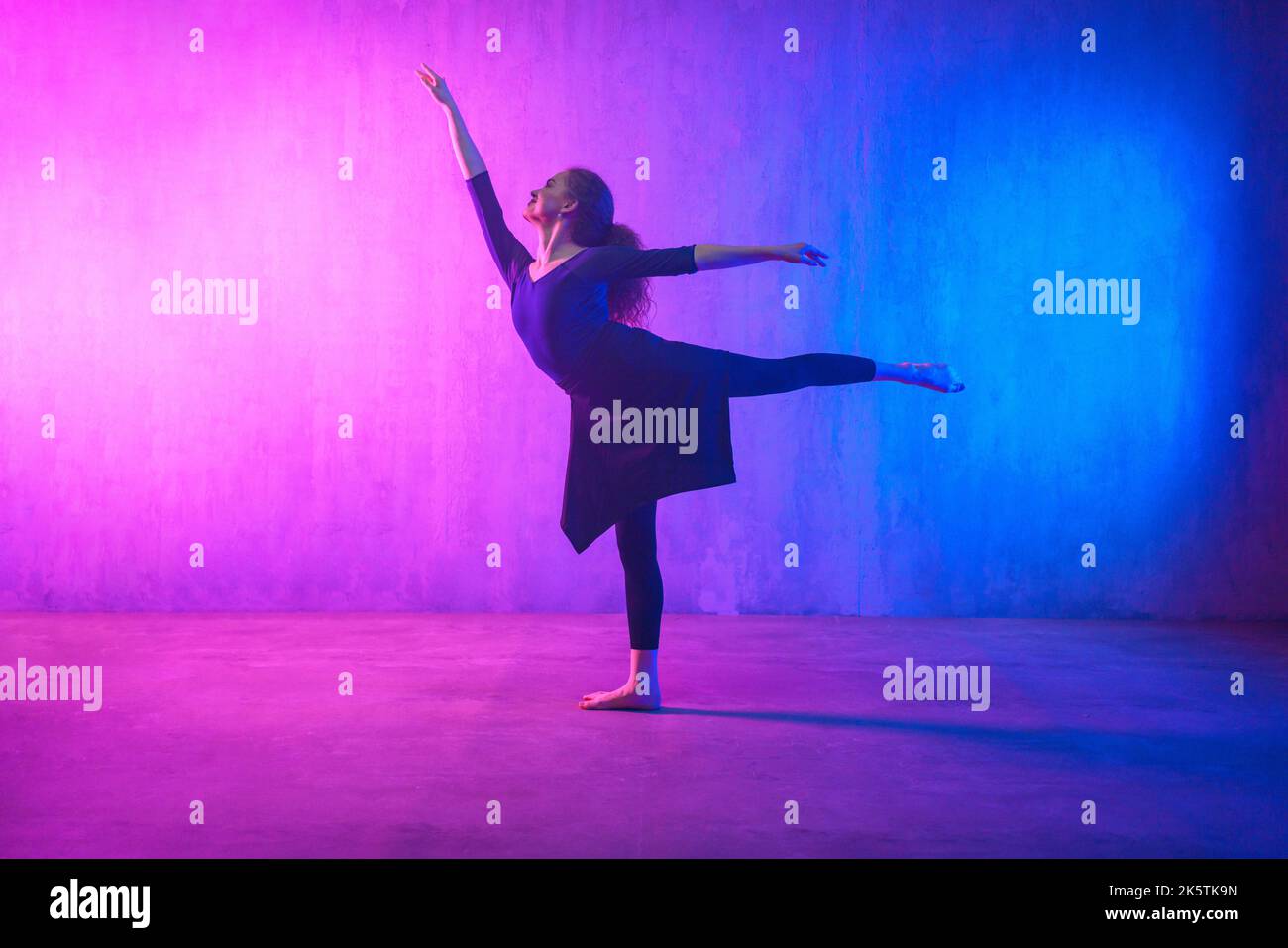 Modern dance girl dancer dancing in neon light doing gymnastic