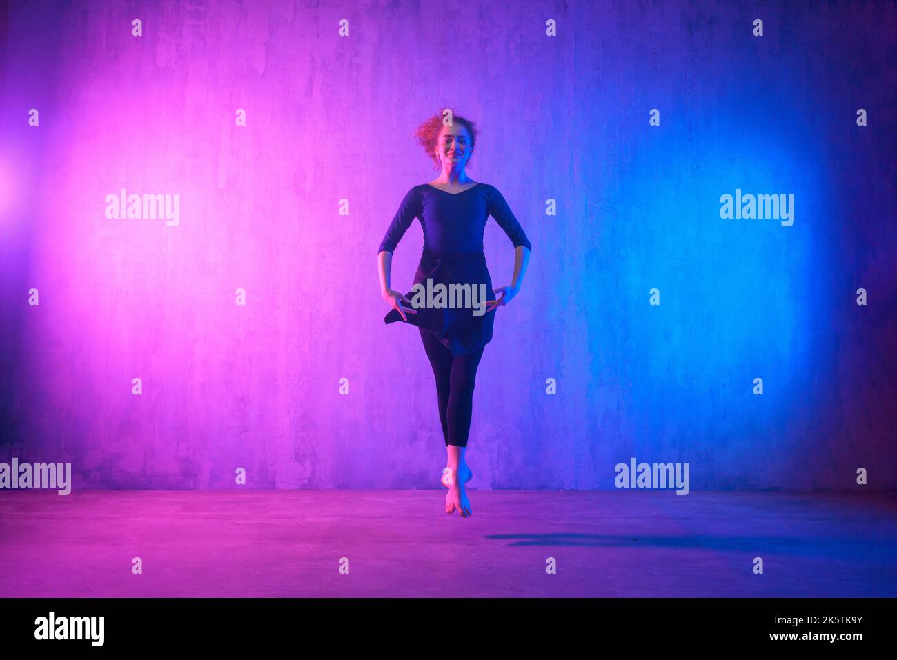 Modern dance girl dancer dancing in neon light doing gymnastic