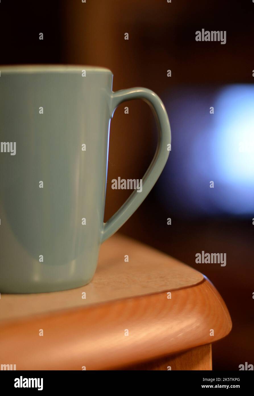 coffee mug on edge of wooden table Stock Photo