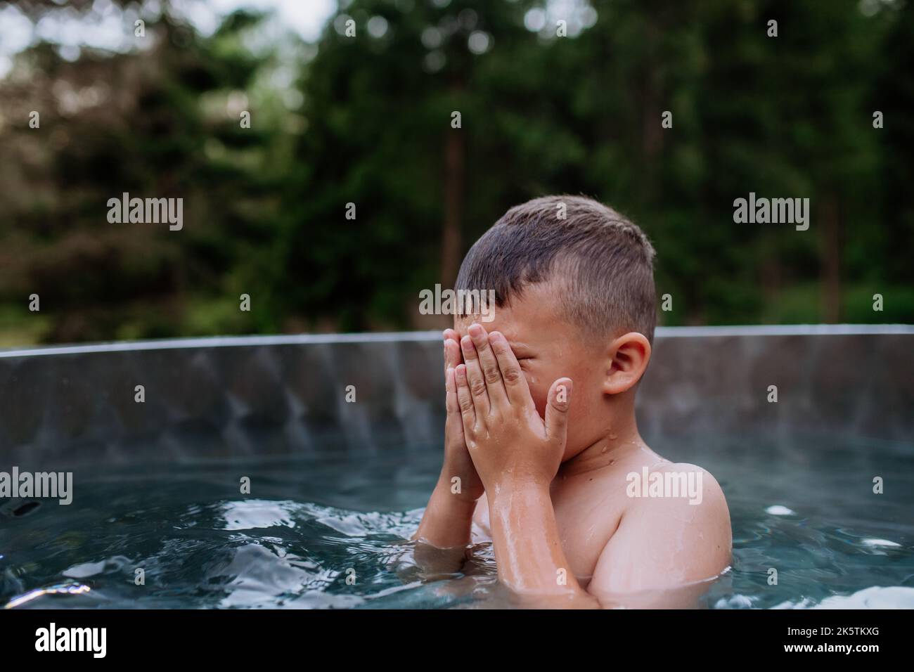 Little boy in outdoor hot tub. Summer holiday, vacation concept Stock