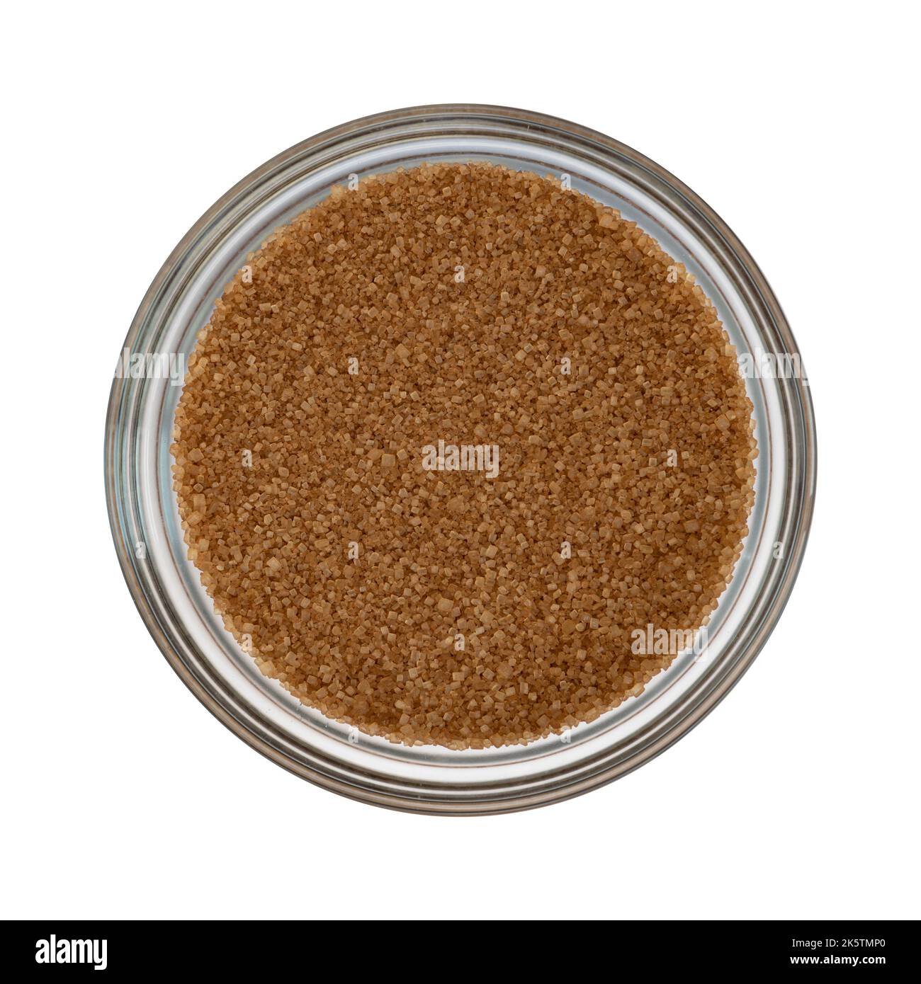 top view of unrefined natural brown sugar in glass bowl isolated on white background, cane sugar close-up Stock Photo