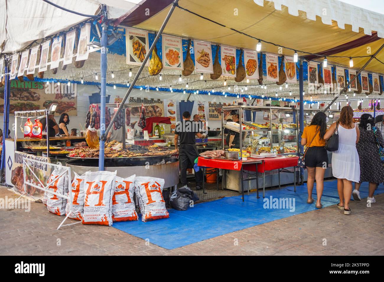 Food stand meat, at annual celebration of the festive Feria in Fuengirola, Costa del Sol, Spain. Stock Photo