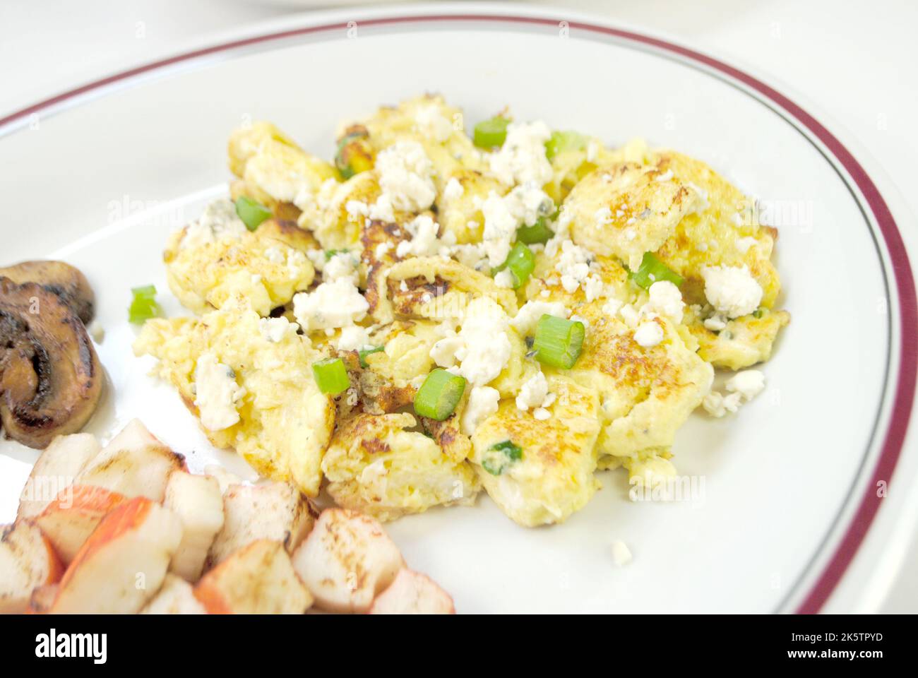 Scallion and Blue Cheese Scrambled Eggs with Side Dishes of Sauteed Mushrooms and Crab Meat Sticks Stock Photo