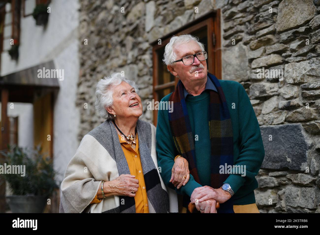 Happy senior couple posing near old countryside house. Stock Photo
