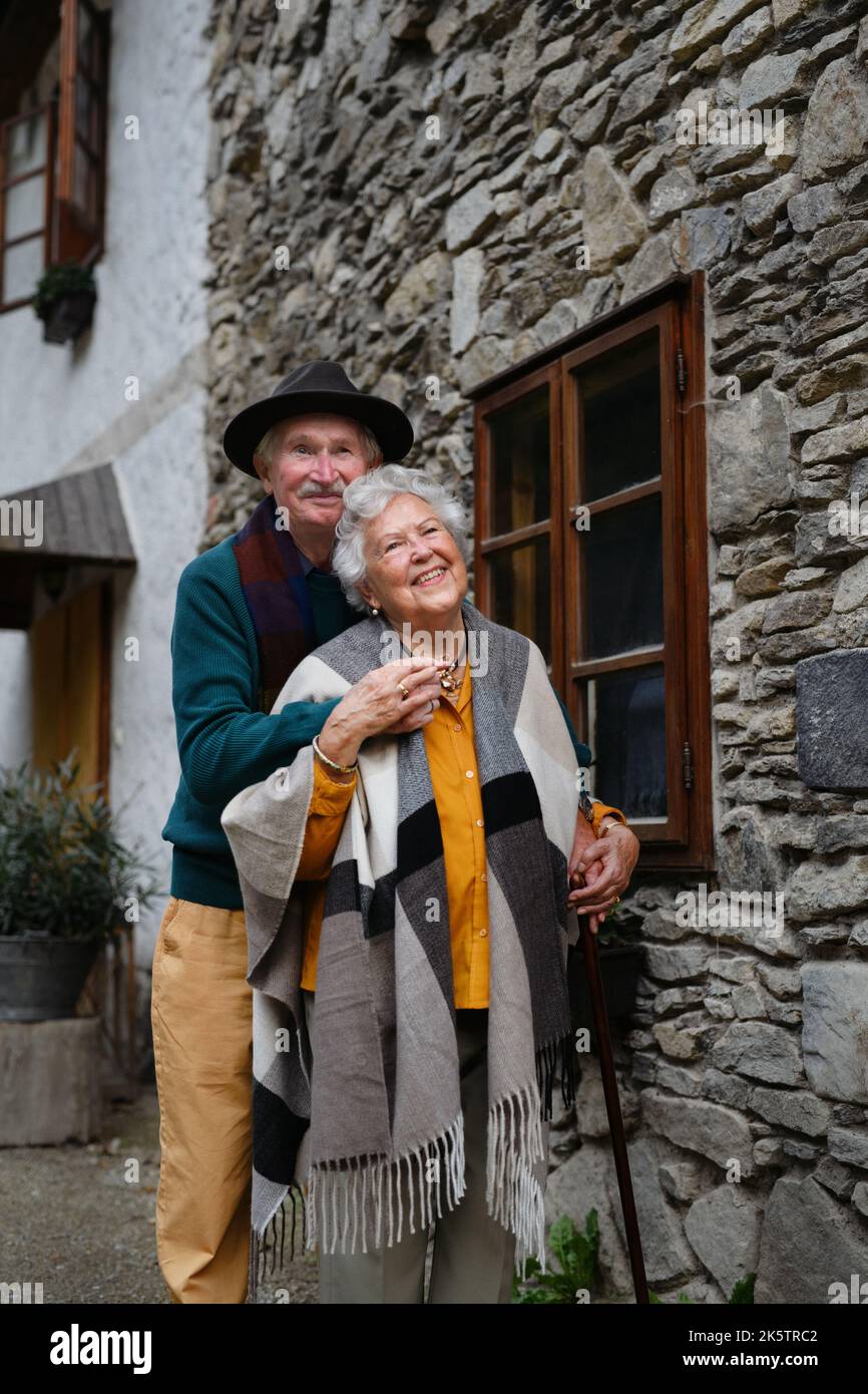 Happy senior couple posing near old countryside house. Stock Photo