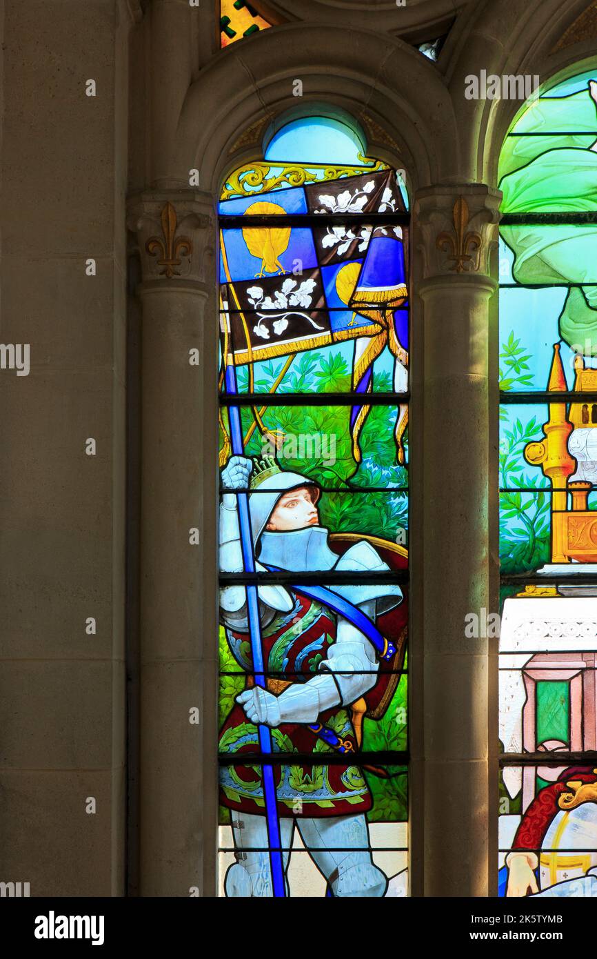 A knight holding a banner with his coat of arms on a stained glass window at the basilica of Bois-Chenu in Domrémy-la-Pucelle (Vosges), France Stock Photo
