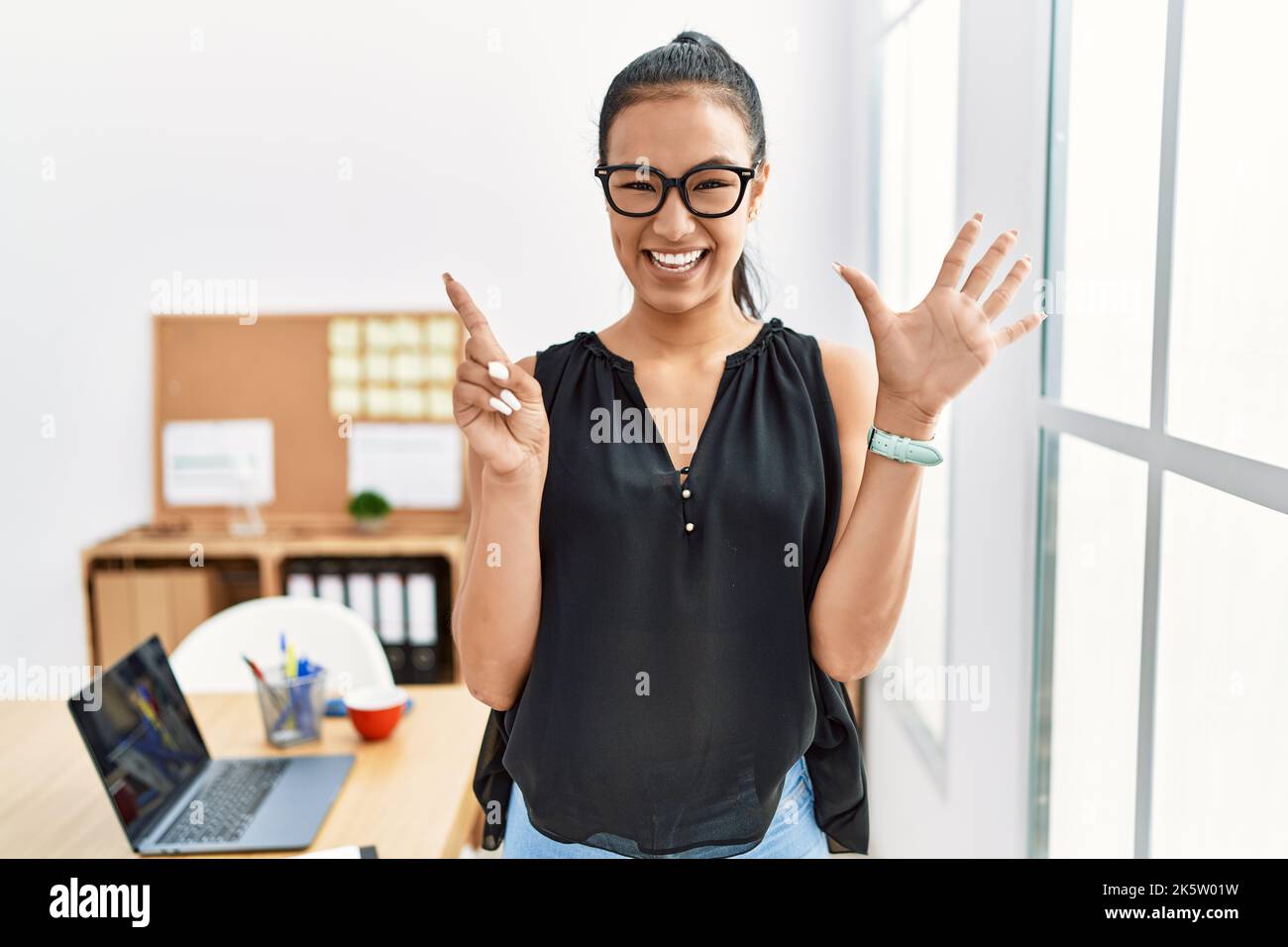 Young hispanic business woman working at the office showing and ...