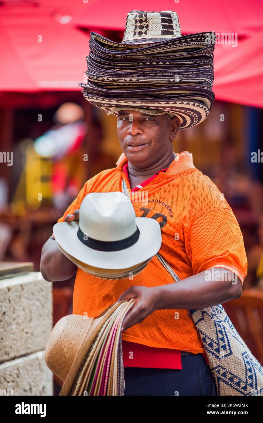 Colombia, the old city of Cartagena is within walls and protected by UNESCO world heritage status. A man is selling hats to tourists in the hisrorical Stock Photo