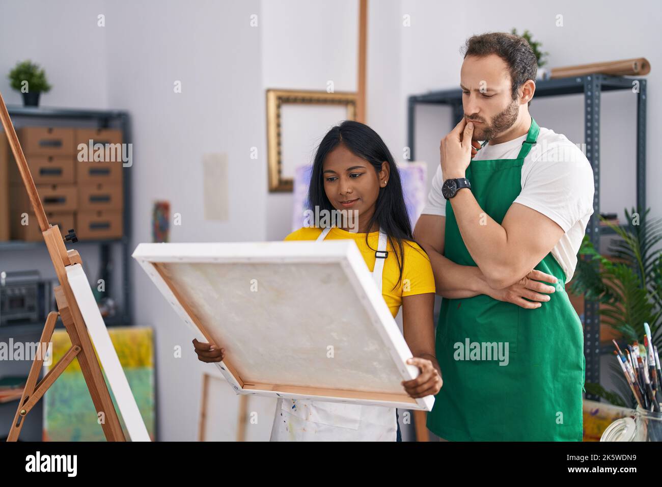Man and woman artist couple looking canvas draw at art studio Stock ...
