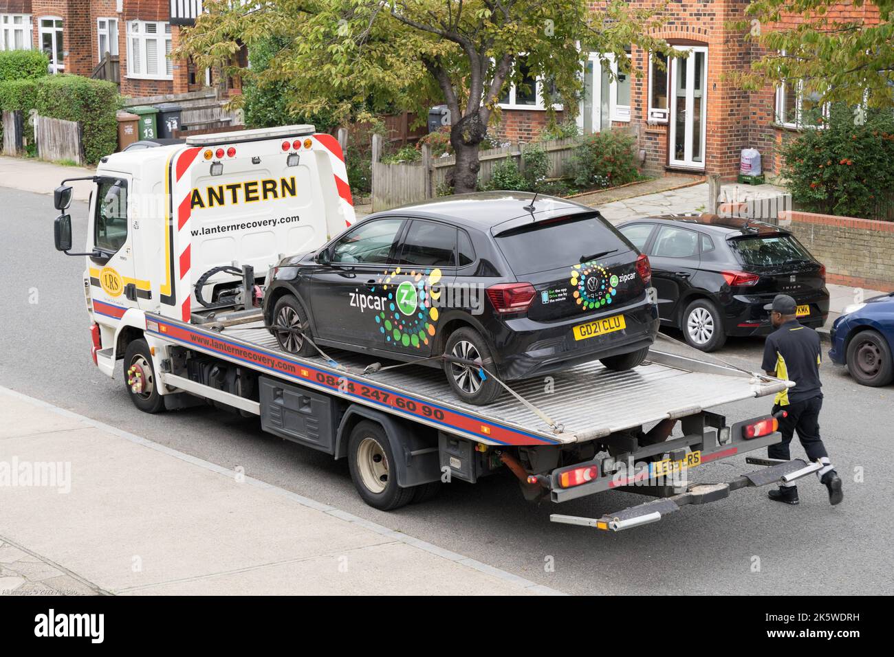break-down zipcar car is hoisted onto a loading ramp and secured on a recovery lorry from LANTERN London England Europe Stock Photo