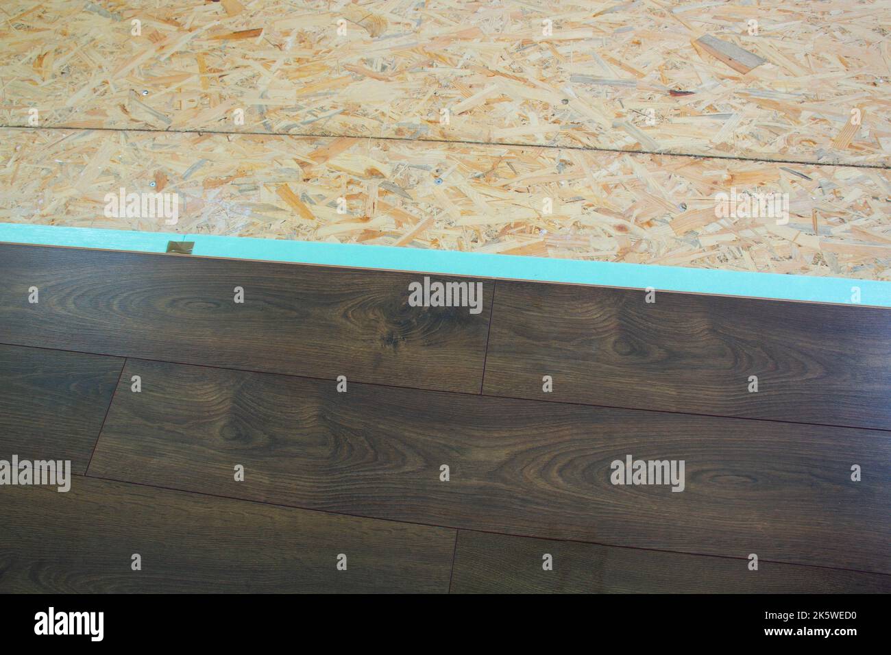 Laminate. Laying brown glossy laminate on the floor of the house