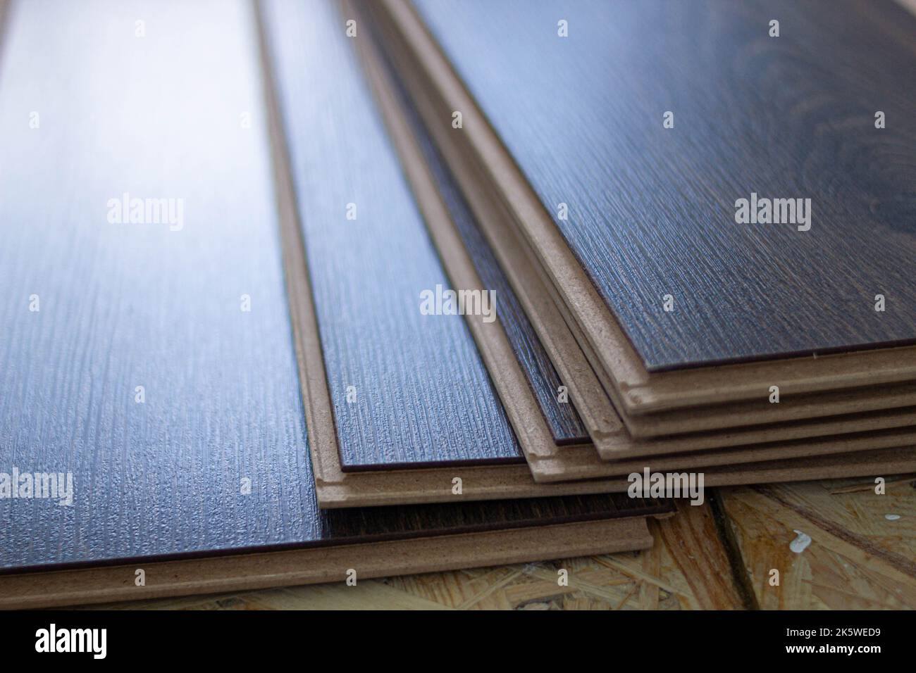 Laminate. Laying brown glossy laminate on the floor of the house