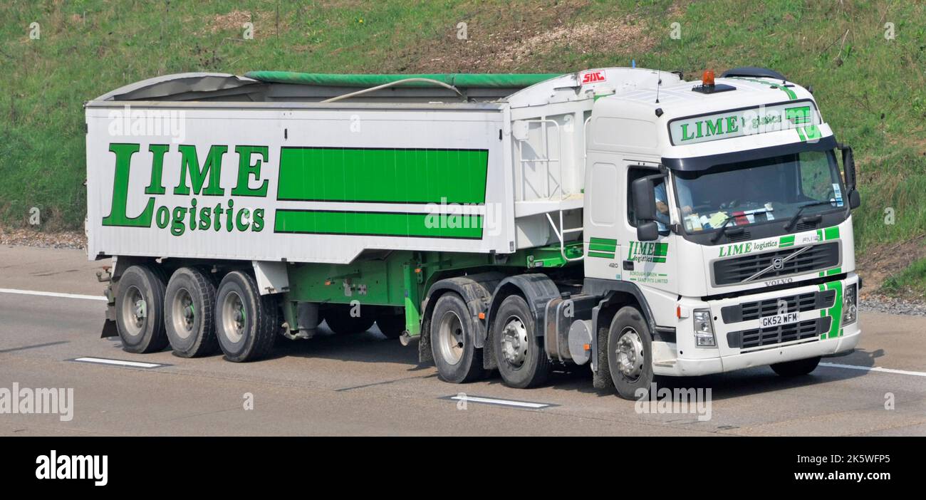 Haulage contractor business Lime Logistics delivers bulk aggregates & waste products in vehicles such as Volvo lorry truck& trailer UK motorway road Stock Photo