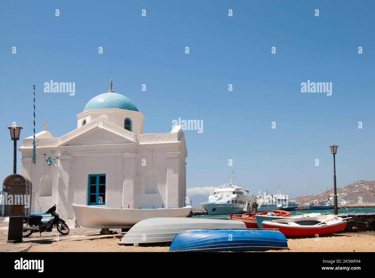 Beached fishing boats and traditional Greek Orthodox church in the port of Mykonos, Greece Stock Photo