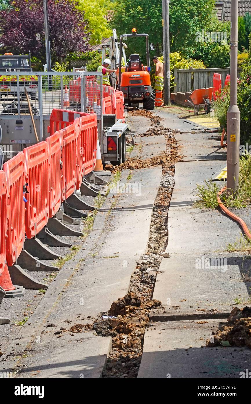 Infrastructure fibre optic broadband main pavement route in shallow trench to be dug out shows short spur for house junction box bottom right Essex UK Stock Photo