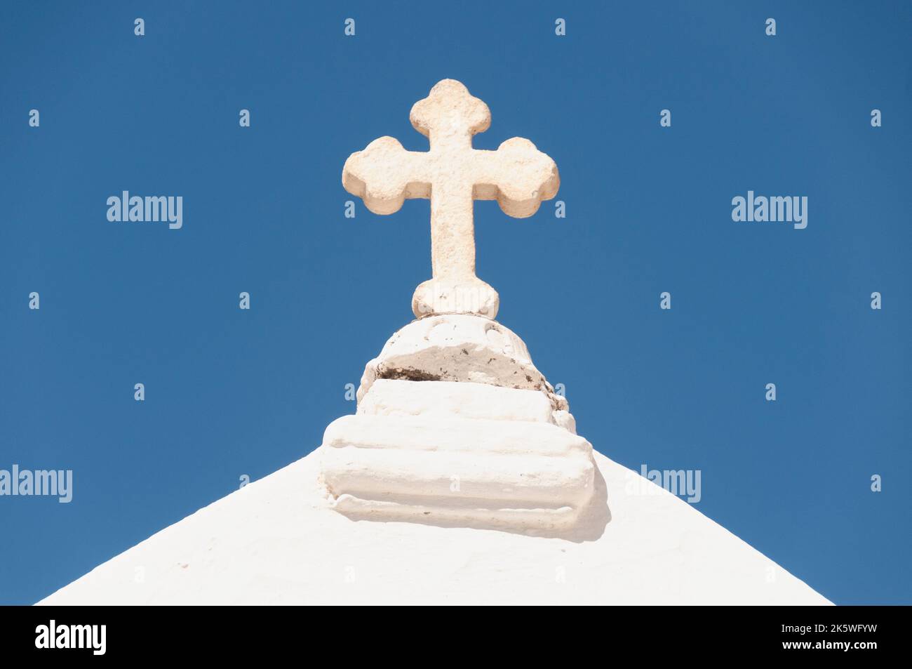 Close-up of the cross on the roof of a Greek church on the island of Mykonos, against the blue sky Stock Photo